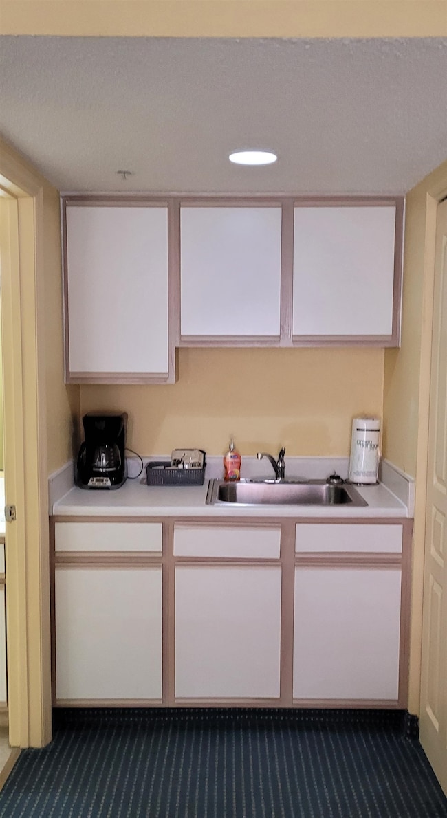 Kitchen featuring sink, carpet floors, and white c