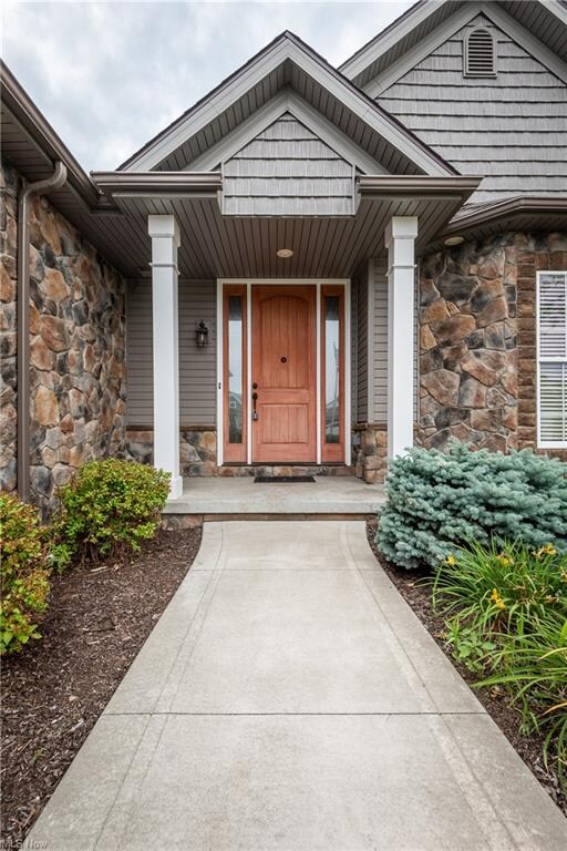 Beautiful stone accents lead to the covered entrance,