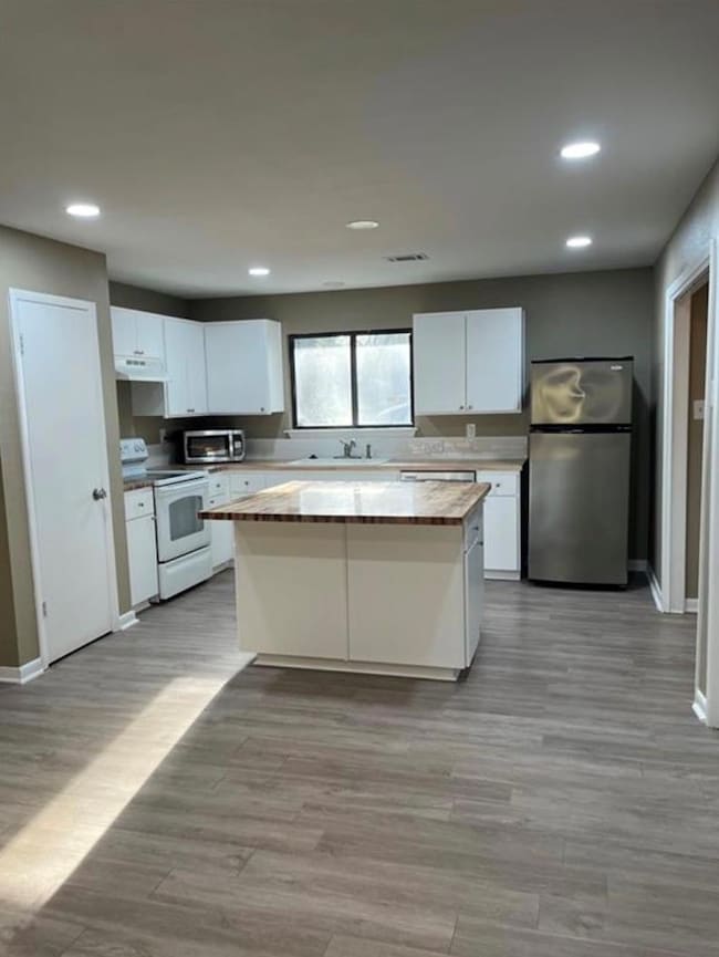 Kitchen featuring white cabinetry, freestanding r