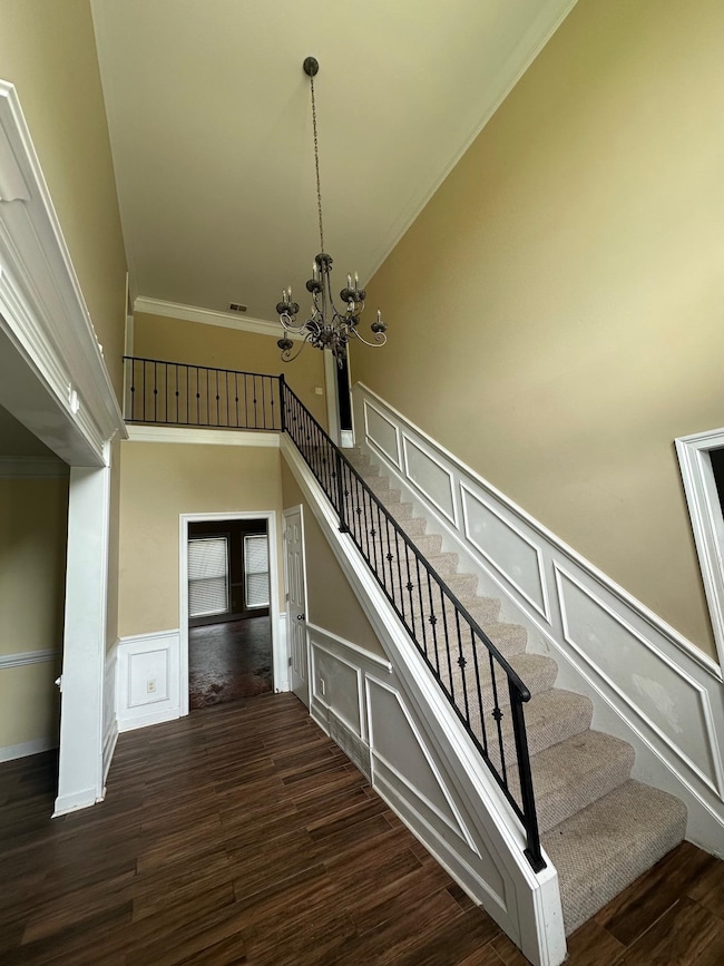 Staircase with a chandelier, a high ceiling, wood 