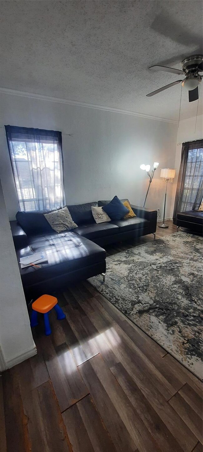 Living area featuring ceiling fan, a textured ceil