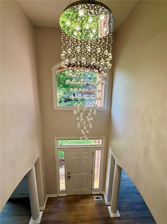 Foyer entrance featuring dark wood-style floors, a high ceiling, and a chandelier