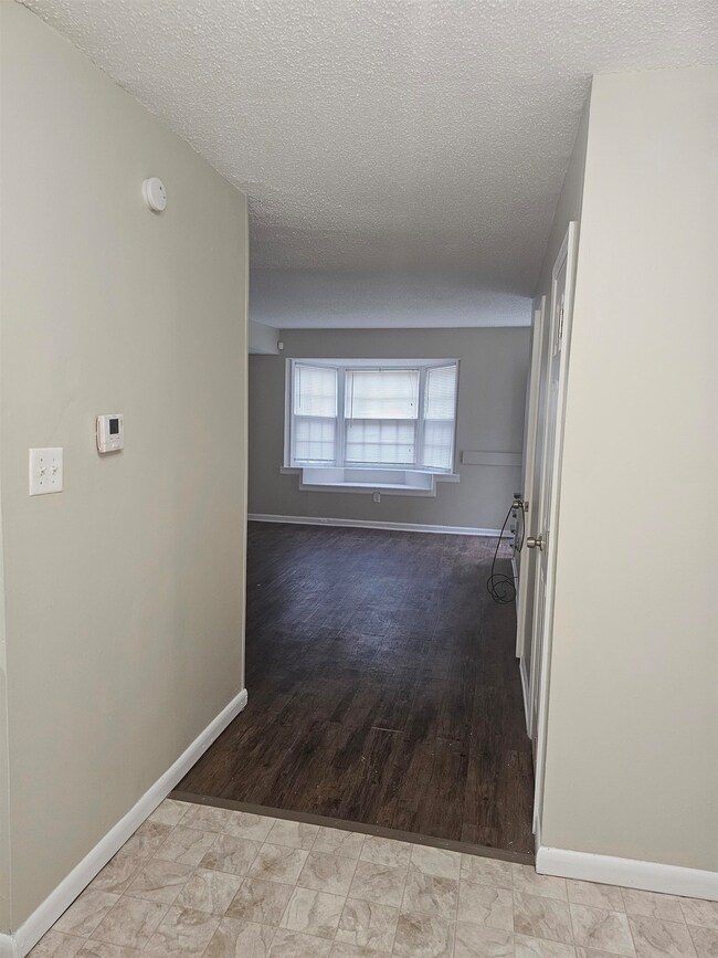 Hall with baseboards and a textured ceiling