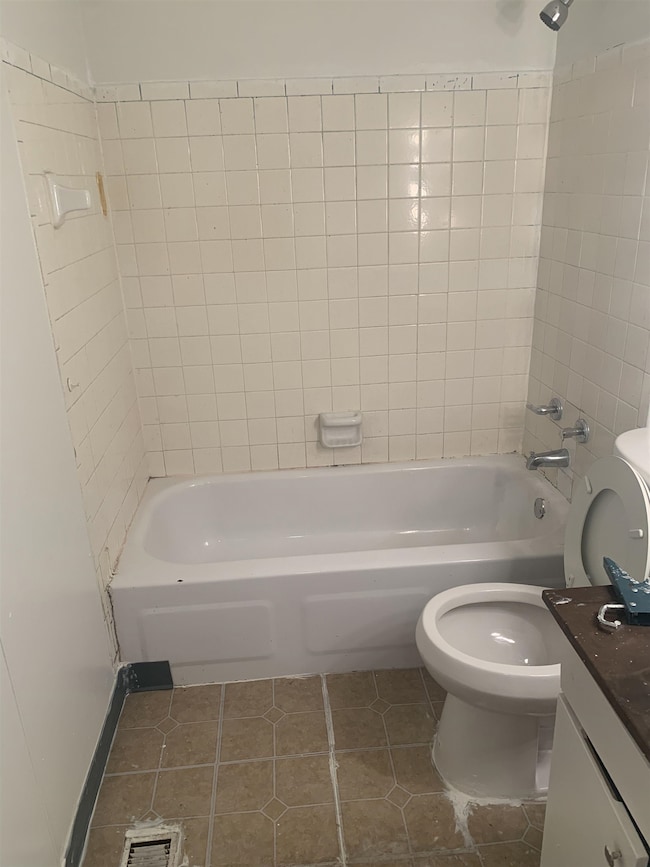 Bathroom featuring tile patterned floors, vanity, and shower / tub combination