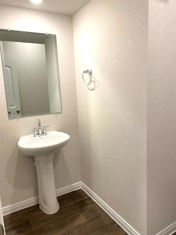 Bathroom with dark wood-style flooring and a text