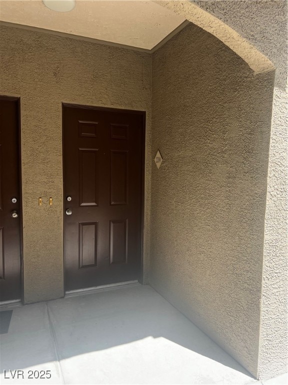 Doorway to property with stucco siding