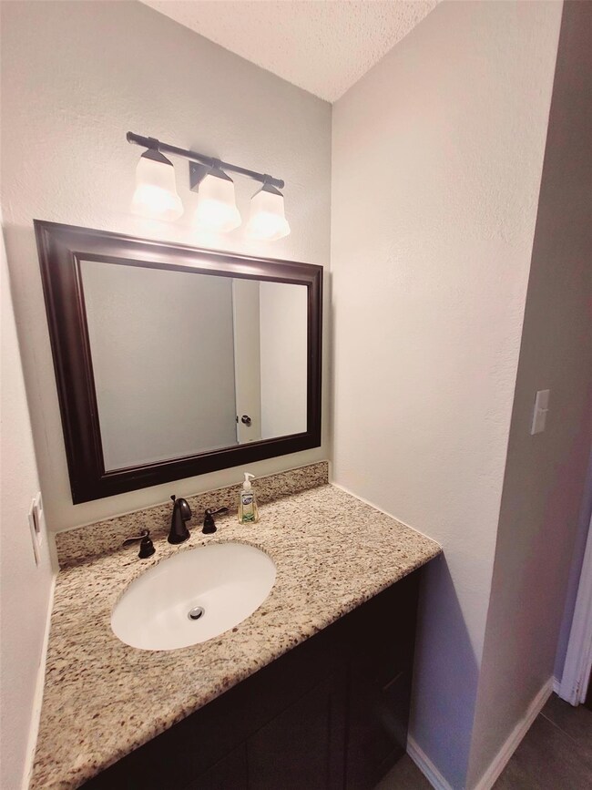 Bathroom with vanity and a textured ceiling