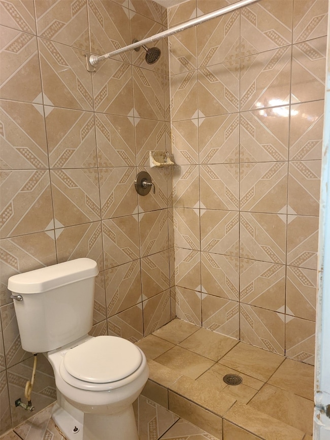 Bathroom with a stall shower and tile walls
