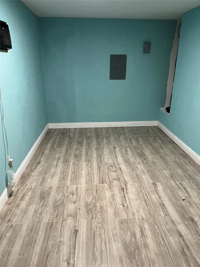Spare room featuring baseboards, wood finished fl