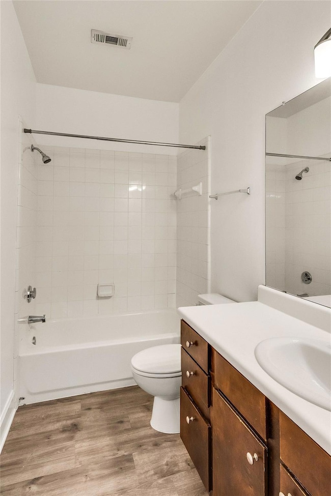Bathroom with vanity, shower / tub combination, and wood finished floors