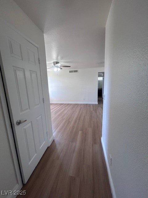 Corridor featuring baseboards, visible vents, and