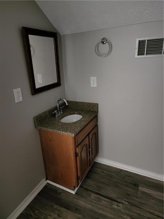 Additional living space featuring a ceiling fan, wood finished floors, baseboards, lofted ceiling, and a textured ceiling