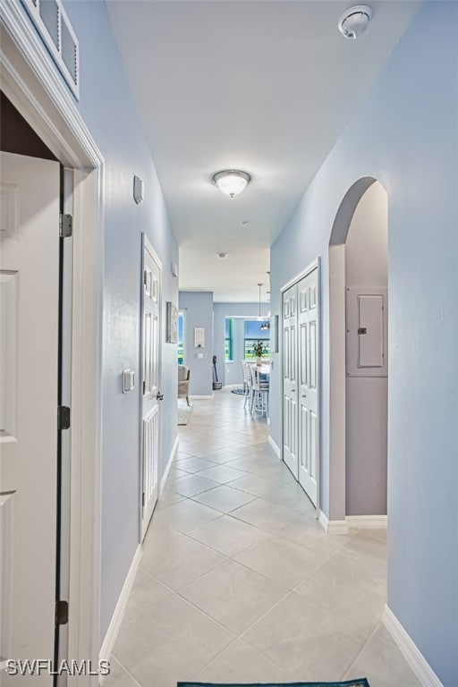 Hallway featuring light tile patterned flooring, a