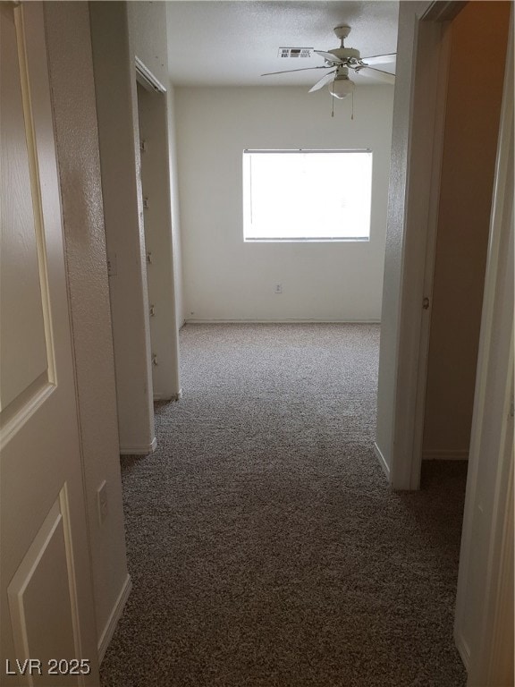 Corridor featuring carpet flooring and baseboards