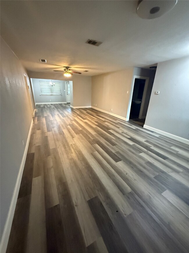 Unfurnished living room featuring dark wood finished floors and a ceiling fan