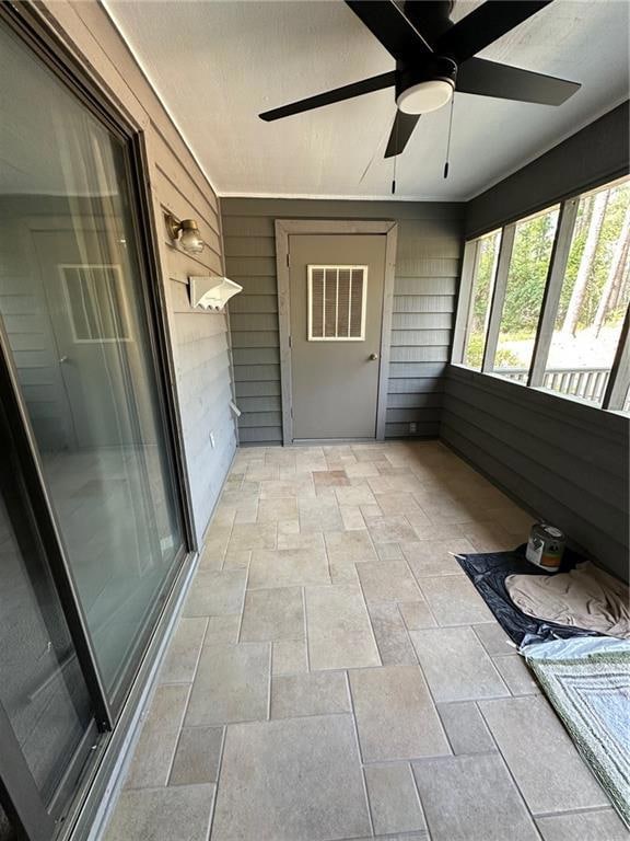 Unfurnished sunroom with ceiling fan