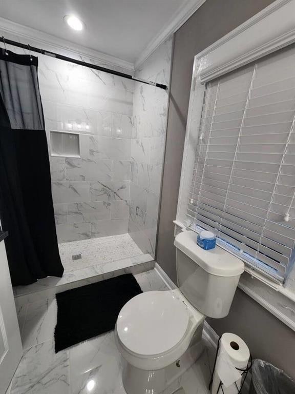 Full bathroom with crown molding, a stall shower, baseboards, toilet, and marble finish floor