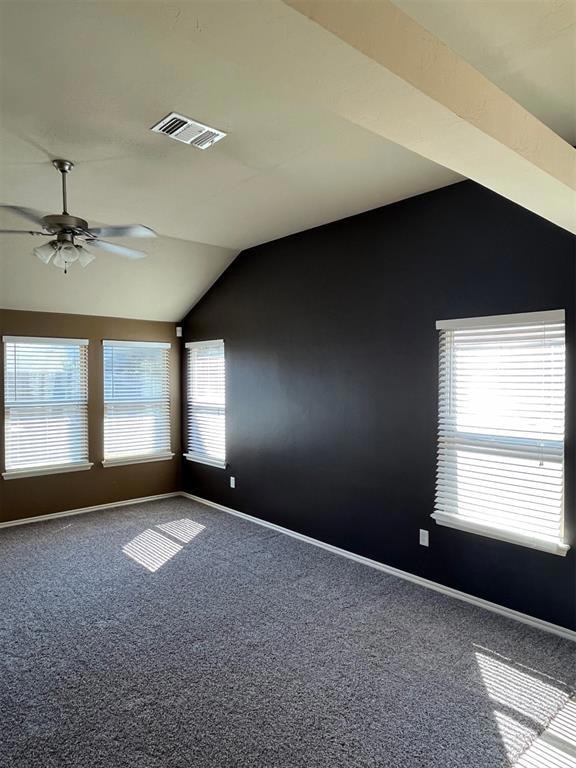 Carpeted empty room featuring lofted ceiling and c