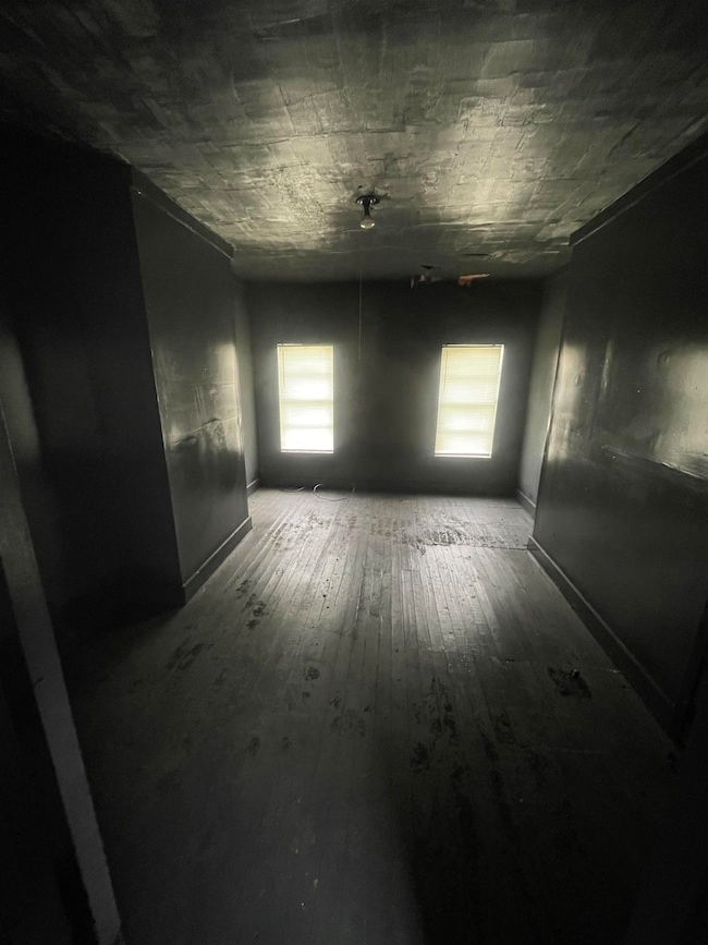 Unfurnished room featuring baseboards and hardwood