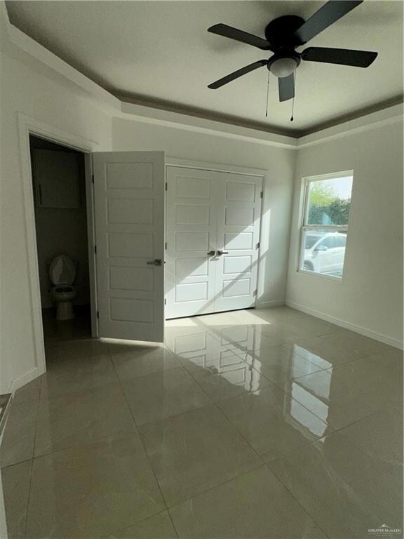 Unfurnished bedroom with baseboards, marble finish floor, and ceiling fan