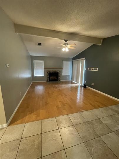 Unfurnished living room with ceiling fan, tile pa