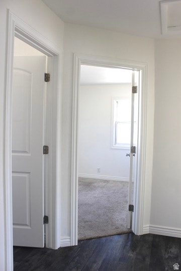 Hallway featuring dark wood-type flooring and baseboards