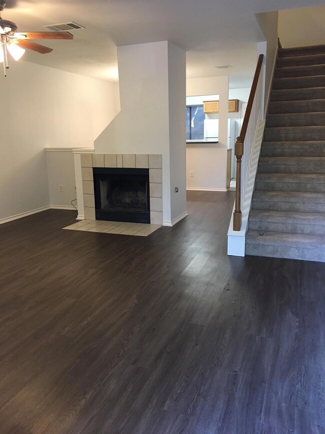 Unfurnished living room with ceiling fan, a firep