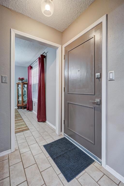 Tiled entrance foyer featuring a textured ceiling