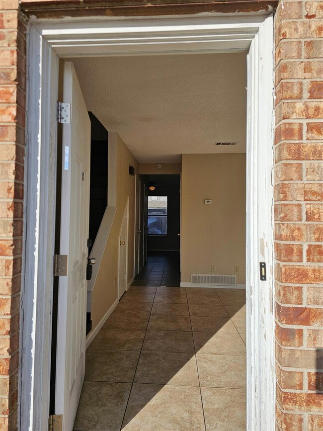 Corridor with dark tile patterned flooring
