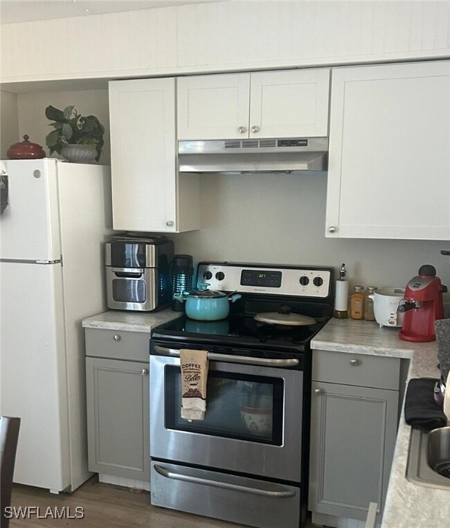 Kitchen with gray cabinetry, under cabinet range h