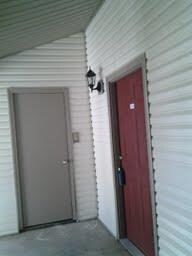 Covered entry to Unit 104 , which is an upstairs f