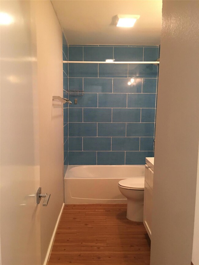 Bathroom featuring wood finished floors, toilet, 