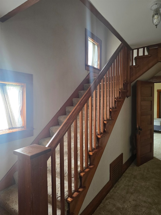 Stairs with carpet flooring and baseboards