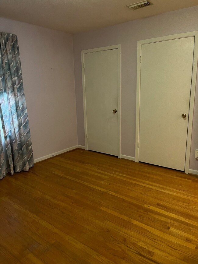 This room features hardwood flooring, two white do