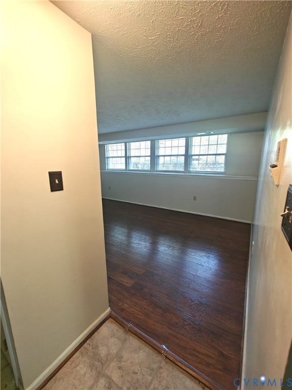 Unfurnished room featuring baseboards and a textured ceiling