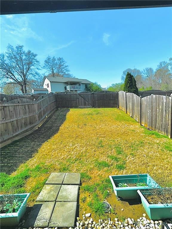 View of yard with a fenced backyard and a vegetabl
