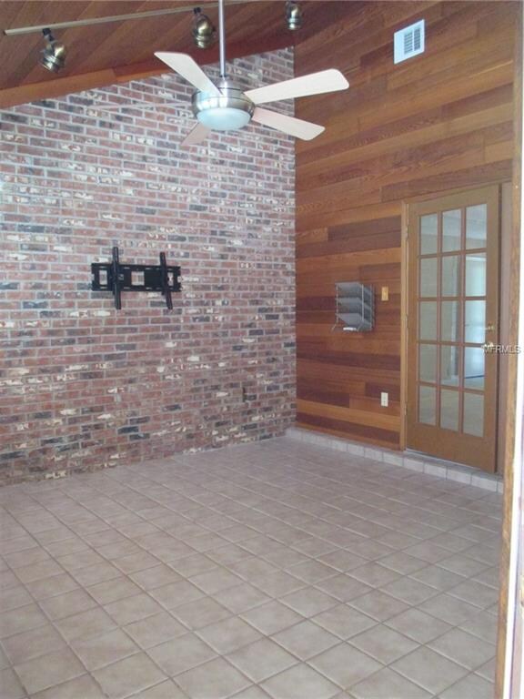 Den/media room with brick and wood accent walls an