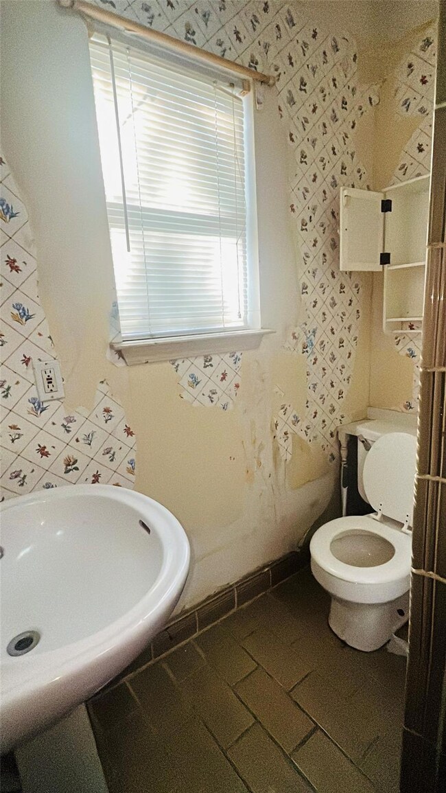 Bathroom featuring toilet, sink, and tile patterne