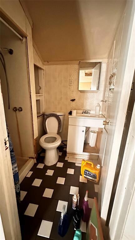 Bathroom with tile walls, curtained shower, and to
