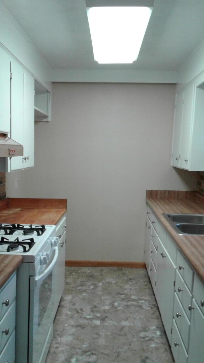 Kitchen w new gas range & flooring