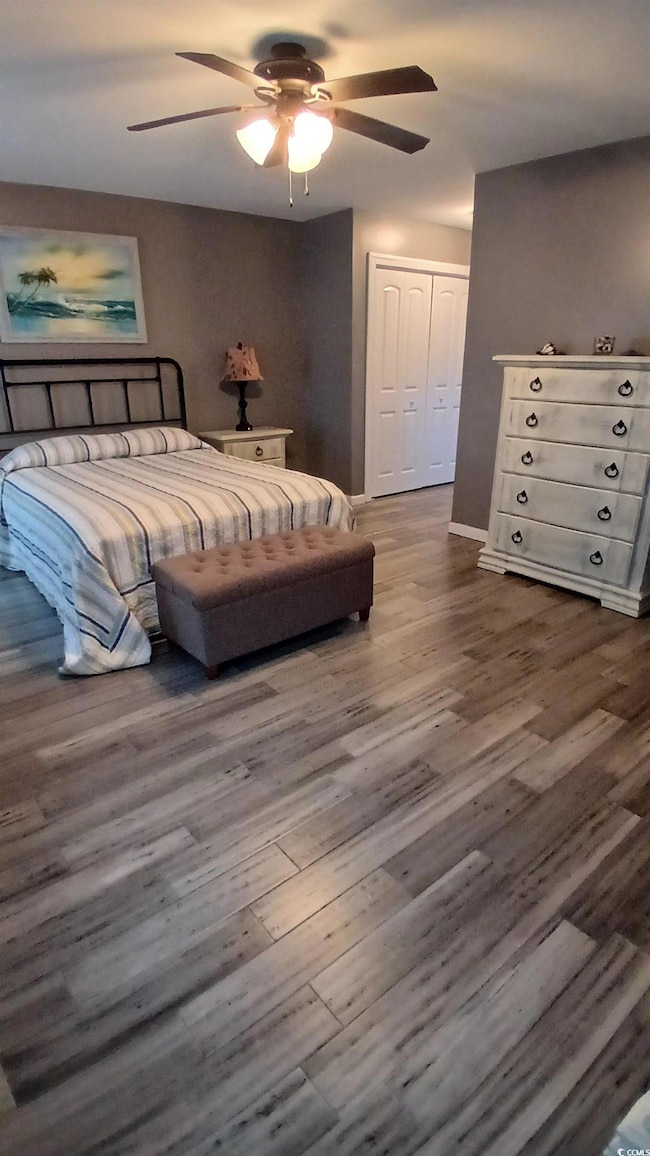 Bedroom with a closet, wood finished floors, and a ceiling fan