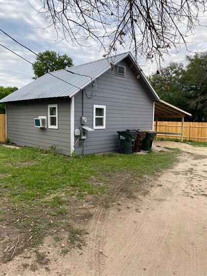 Back of house featuring fence, metal roof, and di