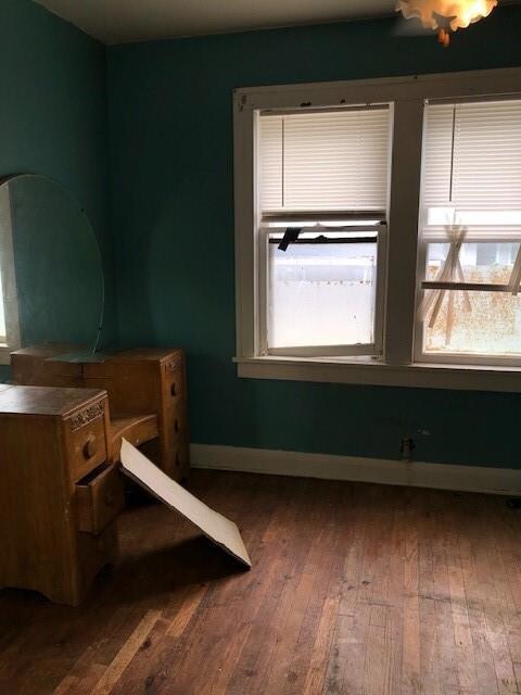 Bedroom with dark wood-type flooring and multiple 