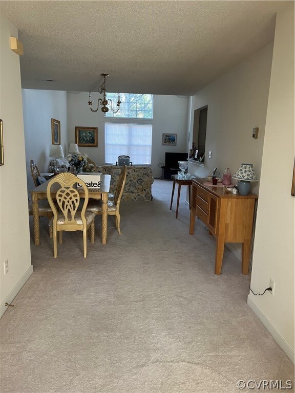 Dining space with a textured ceiling, light carpet