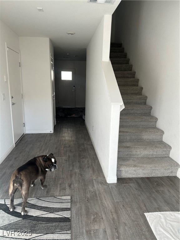 Stairway featuring wood finished floors and basebo