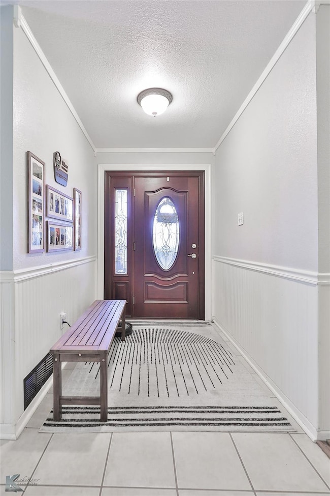 Entrance foyer with light tile patterned floors, a