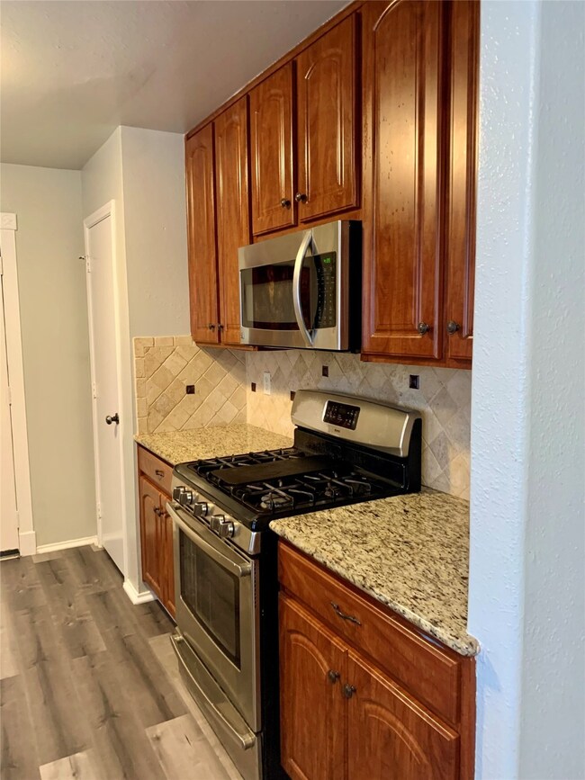 Gas range and microwave that stay with the property. View of door to large pantry.