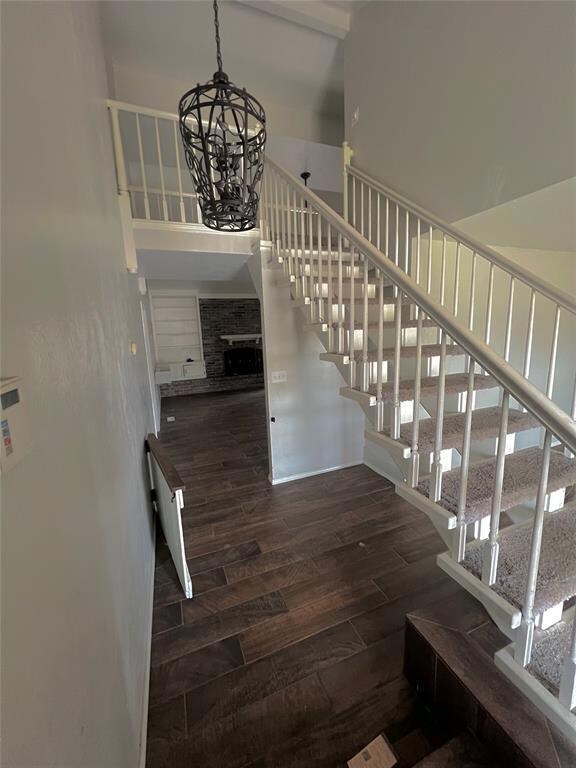 Stairway with a fireplace, an inviting chandelier,