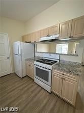 Kitchen with range with gas cooktop, freestanding refrigerator, dark wood-style floors, and extractor fan