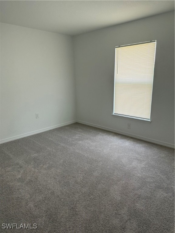 Spare room with baseboards and carpet